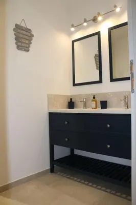 a bathroom with a black sink and two mirrors at Mas en campagne in Mallemort