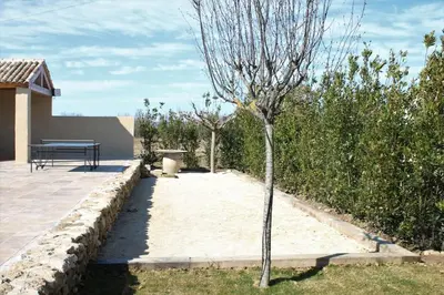 a bench sitting on a patio next to a tree at Mas en campagne in Mallemort