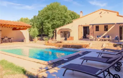 a swimming pool with two chairs and a house at Nice Home In Pernes-Les-Fontaines in Pernes-les-Fontaines