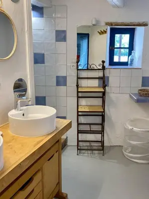 a bathroom with a sink and a towel ladder at Montjoïa Le gîte bleu in Le Thor