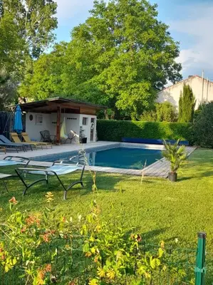a yard with a swimming pool and a house at Montjoïa Le gîte bleu in Le Thor