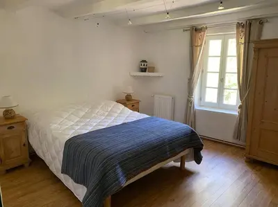 a bedroom with a bed with a blue blanket on it at Montjoïa Le gîte bleu in Le Thor
