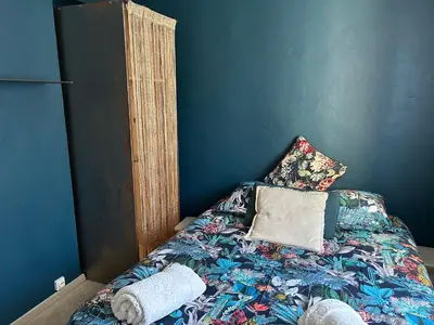 a bed in a room with a blue wall at Nid d'Ange en Provence in Cavaillon