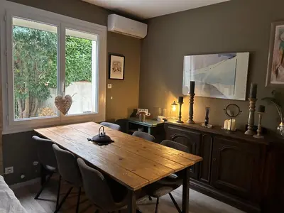 a dining room with a wooden table and a window at Nid d'Ange en Provence in Cavaillon