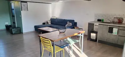 a living room with a table and a blue couch at Loft en duplex au Mas de la Restanque in Monteux