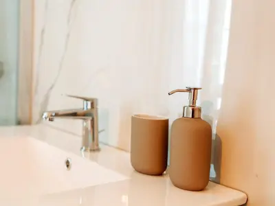a bathroom with two soap dispensers on a sink at Le constantinou in Saint-Michel-lʼObservatoire
