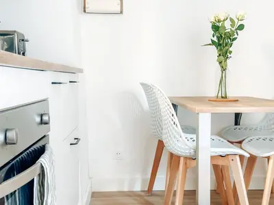 a dining room table with two chairs and a vase of flowers at Le constantinou in Saint-Michel-lʼObservatoire