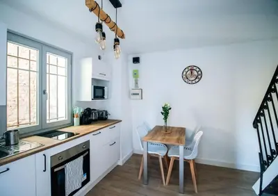 a kitchen with a table and a small table and chairs at Le constantinou in Saint-Michel-lʼObservatoire