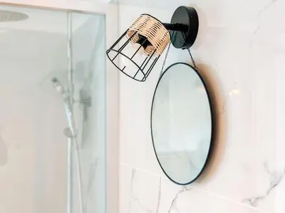 a mirror hanging on a wall next to a shower at Le constantinou in Saint-Michel-lʼObservatoire