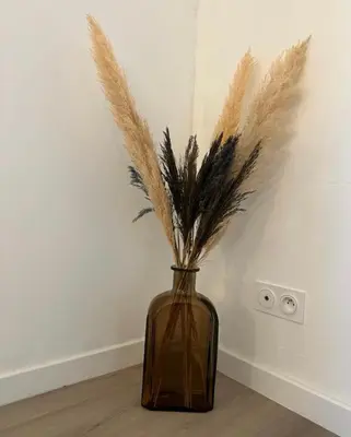 a vase with grasses in it sitting on the floor at L’Amistouso in Vedène