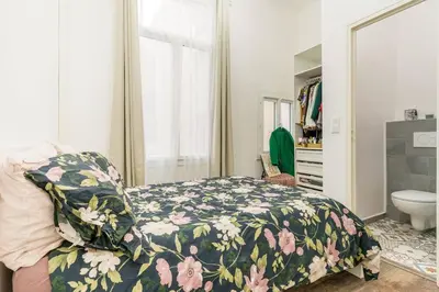 a bedroom with a bed with a floral comforter at Duplex en plein centre historique Aix en provence in Aix-en-Provence