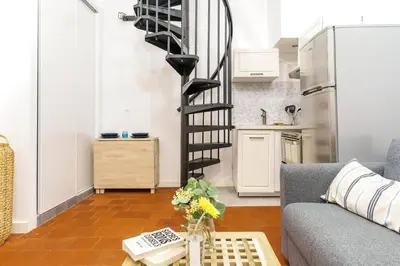 a living room with a staircase and a couch at Duplex en plein centre historique Aix en provence in Aix-en-Provence