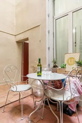 a table and two chairs and a bottle of wine at Duplex en plein centre historique Aix en provence in Aix-en-Provence