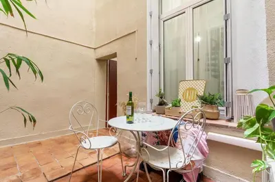 a table and chairs on a balcony with a bottle of wine at Duplex en plein centre historique Aix en provence in Aix-en-Provence