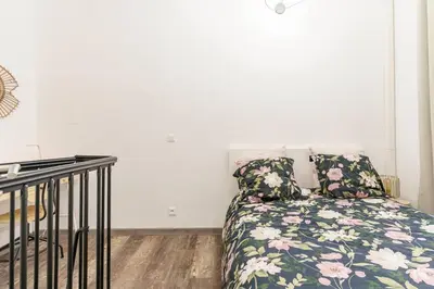 a bedroom with a bed with a floral pillow at Duplex en plein centre historique Aix en provence in Aix-en-Provence
