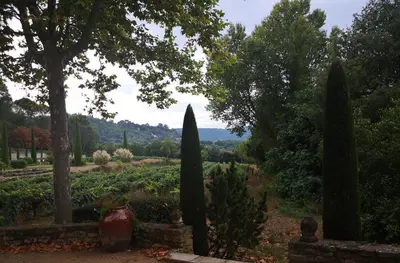 a garden with cypress trees and a view of the mountains at GÎTE DE L 'OCRE NICE VIEW in Villars