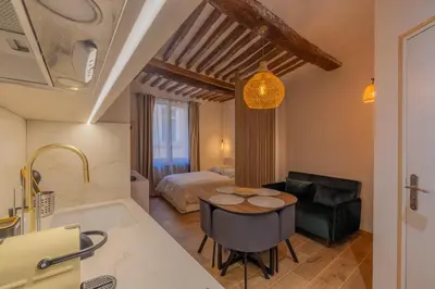 a kitchen and living room with a table and a bed at Appartement de charme in Aix-en-Provence