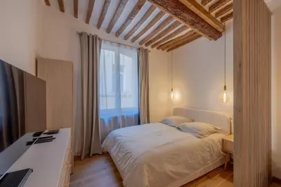 a bedroom with a bed and a large window at Appartement de charme in Aix-en-Provence