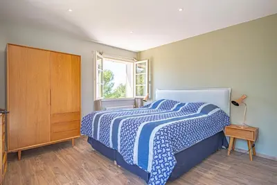 a bedroom with a blue and white bed and a window at Villa des Fontaines luxury family home with pool in Pernes-les-Fontaines
