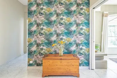 a vase on a wooden table in a room with a wallpaper at Villa des Fontaines luxury family home with pool in Pernes-les-Fontaines