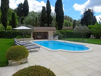 a swimming pool with a patio and an umbrella at Villa Le Bouloulou by Interhome in Velleron