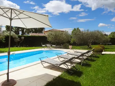 a pool with two lounge chairs and an umbrella at Villa Le Bouloulou by Interhome in Velleron