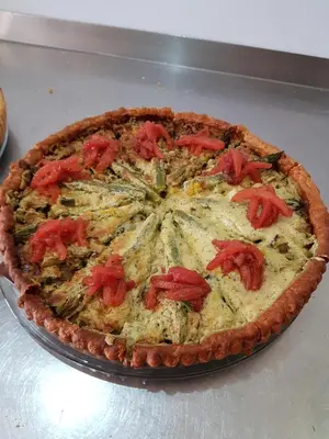a pizza with tomatoes on it sitting on a table at Le Moulin de Lavon in Gargas
