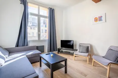 a living room with a couch and chairs and a tv at Studio place cardeurs in Aix-en-Provence