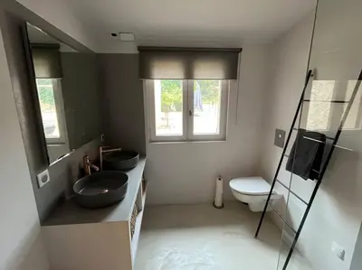 a bathroom with a sink and a toilet and a window at Jolie maison avec vue imprenable, piscine, jeu de boules, calme au cœur du Luberon in Les Cordiers
