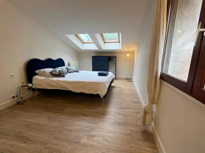 a bedroom with a bed and a skylight at Jolie maison avec vue imprenable, piscine, jeu de boules, calme au cœur du Luberon in Les Cordiers