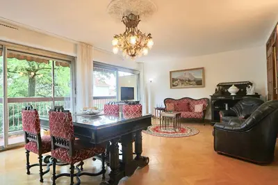 a dining room with a table and chairs and a chandelier at Le Jourdan clim' terrasse ascenseur garage in Aix-en-Provence