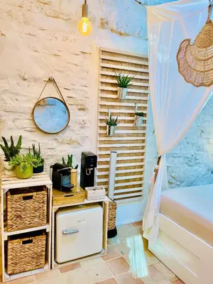 a bedroom with a bed and a table with a mirror at Histoire de cru in Saignon