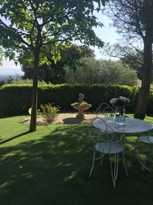 a table and chairs in a yard with a fountain at Chambre d hôte Lavande 