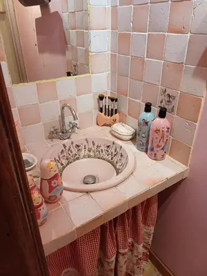 a bathroom counter with a sink and bottles on it at Chambre d hôte Lavande 
