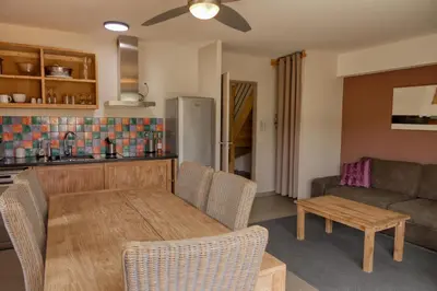 a kitchen and living room with a table and a couch at Souleia in Oppède