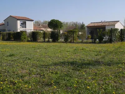 a field of grass with a fence and a house at Souleia in Oppède