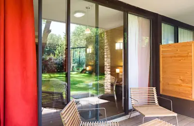 a screened in porch with two chairs and a table at Moulin de Vernègues Hôtel & Spa in Mallemort