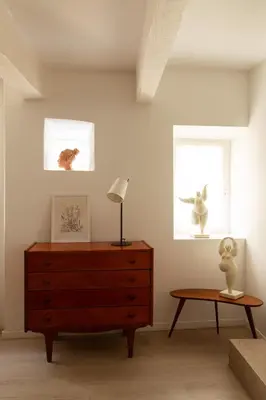 a bedroom with a dresser and a lamp and a table at Maison de village Arty et terrasse au calme in Lourmarin