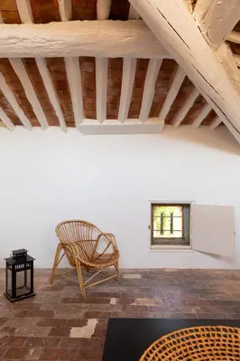 a room with a chair and a table and a window at Maison de village Arty et terrasse au calme in Lourmarin