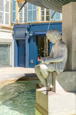 a statue of a woman sitting next to water at La Réserve de Salon de Provence in Salon-de-Provence