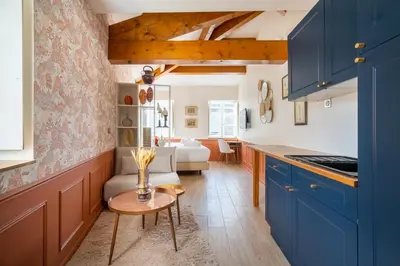 a kitchen with blue cabinets and a table at La Réserve de Salon de Provence in Salon-de-Provence