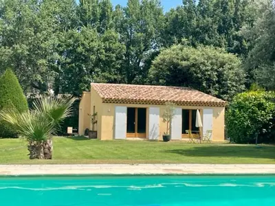a small house next to a pool of water at Charmante maisonnette avec jardin et piscine in Aix-en-Provence