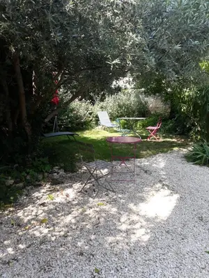 a table and two chairs sitting in a yard at La maison du jardin in Rustrel