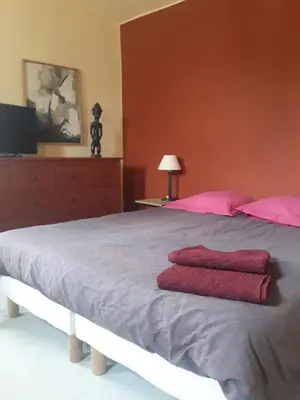 a bedroom with a bed with two red towels on it at La maison du jardin in Rustrel