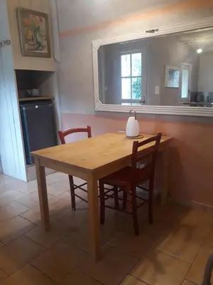 a wooden table and chairs in a kitchen with a window at La maison du jardin in Rustrel