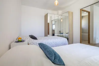 a bedroom with two beds and a mirror at Maison des Fleurs in Vedène