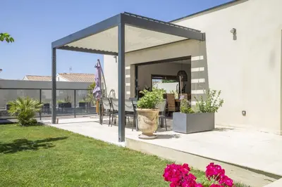a covered patio with a table and chairs at Maison des Fleurs in Vedène