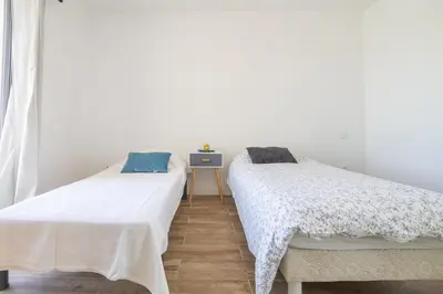 two beds sitting next to each other in a room at Maison des Fleurs in Vedène