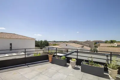 a balcony with potted plants on a roof at Maison des Fleurs in Vedène