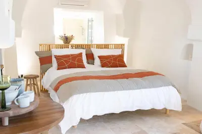 a bedroom with a bed with orange and white pillows at Unique guest room in the heart of Provence 